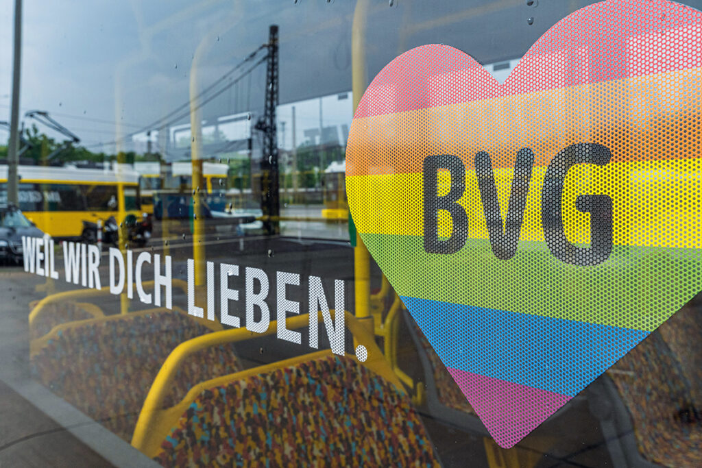 Auf dem Fenster eines Busses klebt ein Herz in den Farben des Regenbogens.