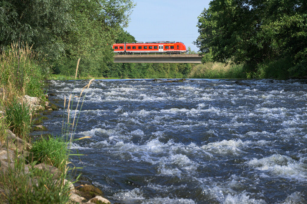 Ein Zug auf einer Brücke über den Fluss Rur.