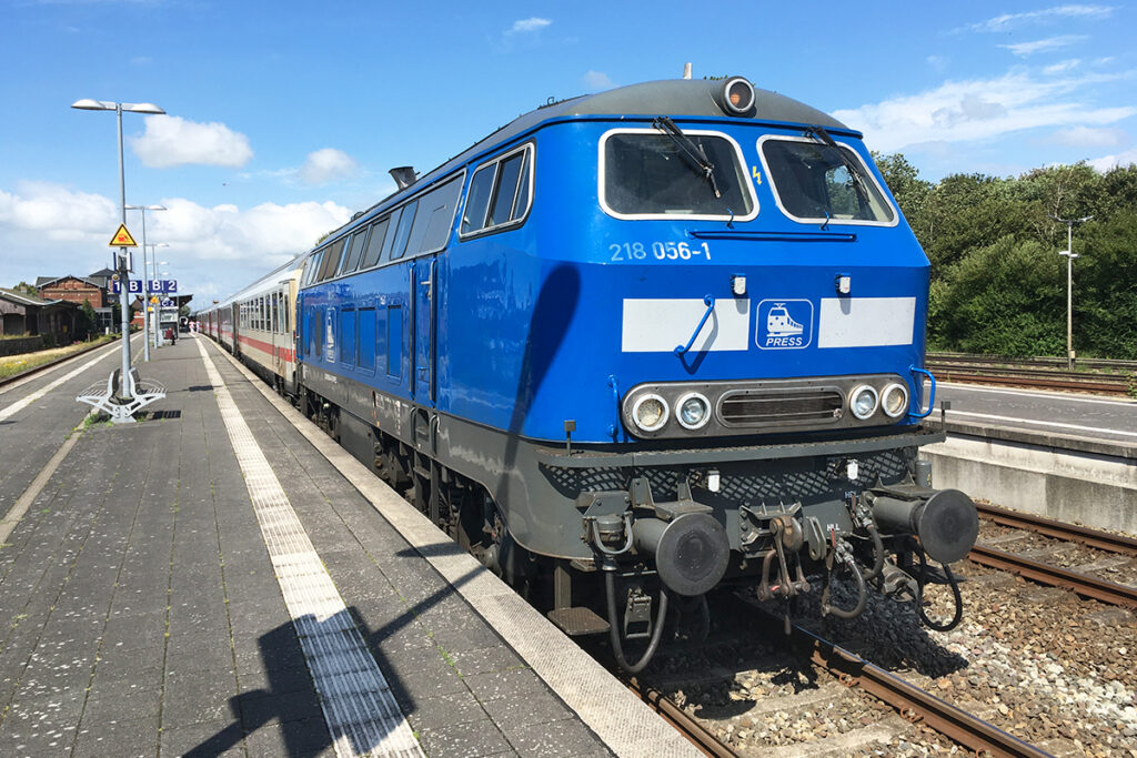 Eine Lokomotive von PRESS steht an einem Bahnsteig in Niebüll.