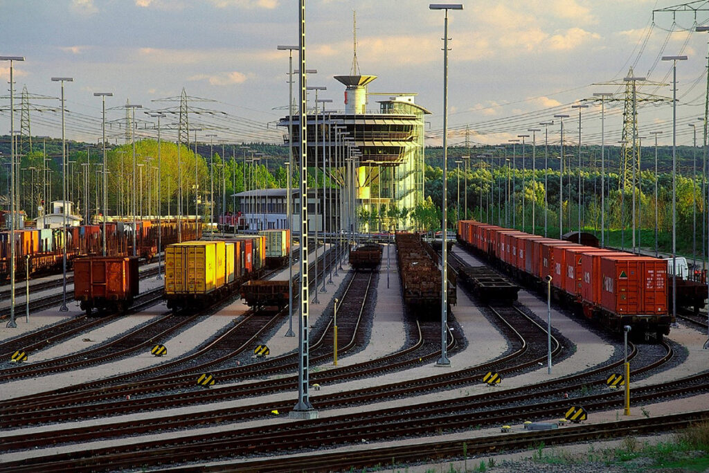 Ein Güterbahnhof mit Güterwagen und einem Stellwerk.