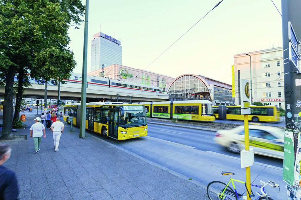 Ein Bus und eine Straßenbahn fahren auf einer Straße in Berlin.