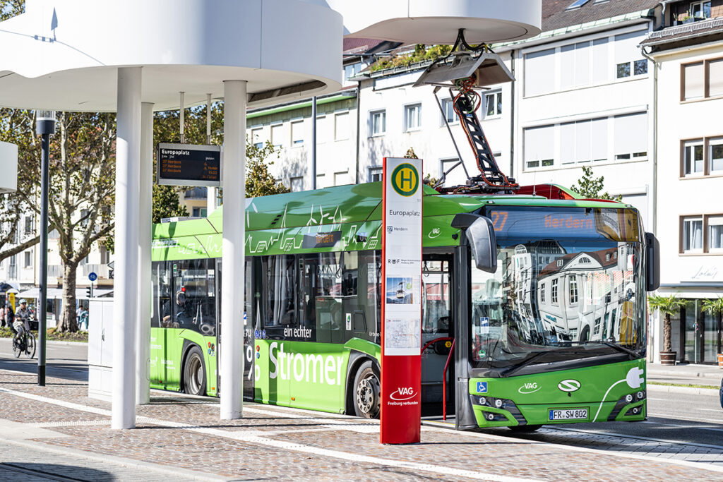 Ein Elektrobus steht an einer Haltestelle.