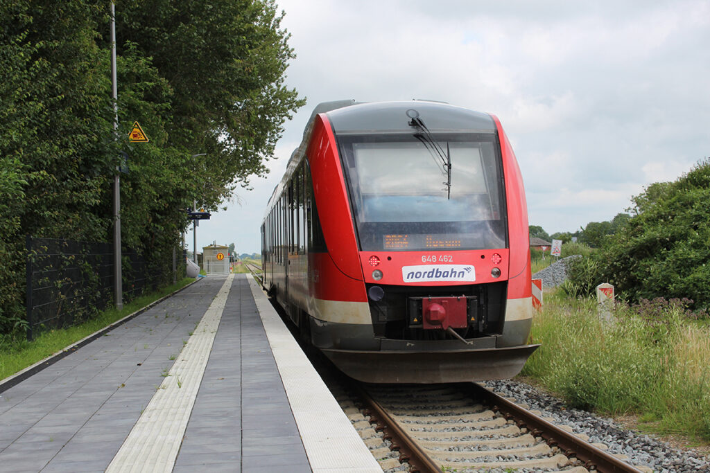 Ein Zug hält an einem Bahnsteig.