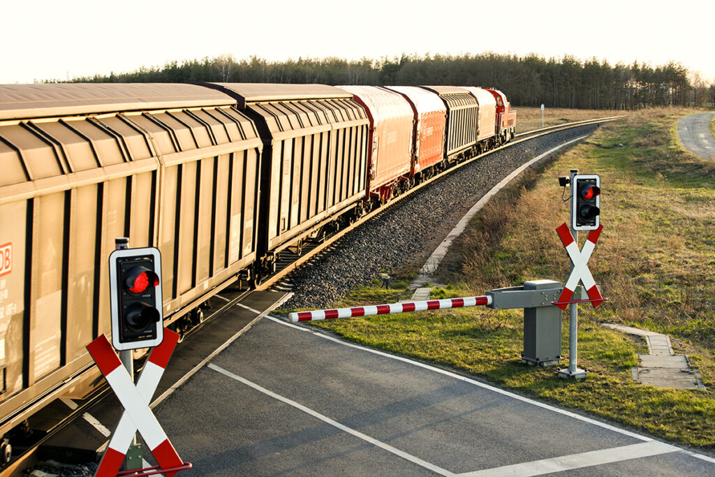 Ein Güterzug überquert einen Bahnübergang.