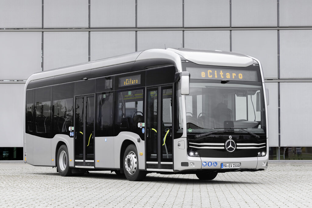 Ein Elektrobus eCitaro K steht vor einer Halle.