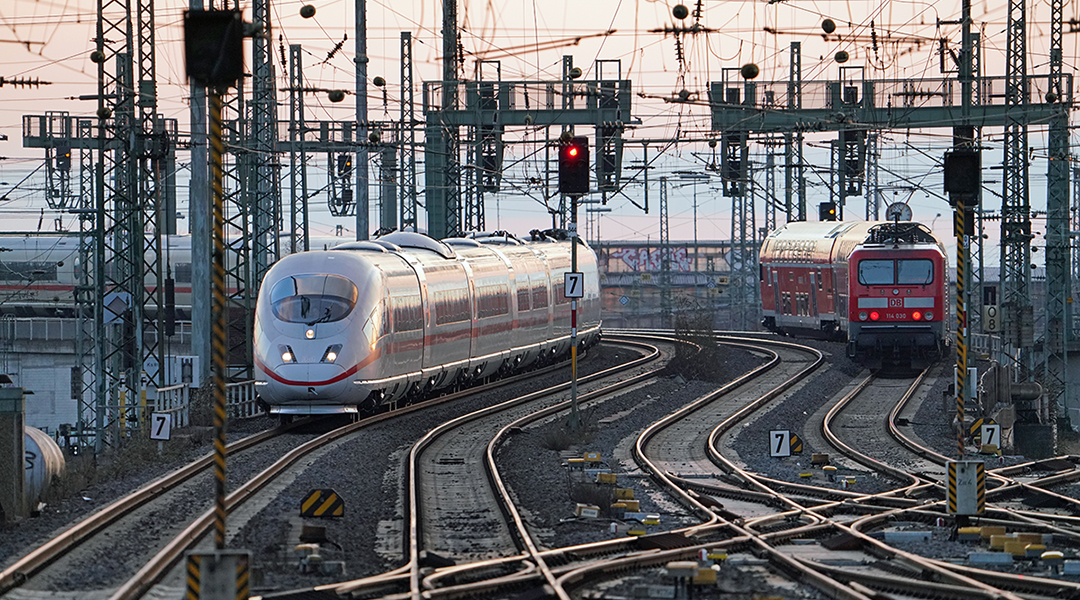 Ein ICE und ein Regionalzug fahren auf Gleisen.