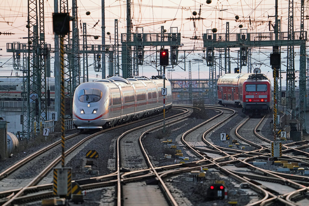 Ein ICE und ein Regionalzug fahren auf Gleisen.