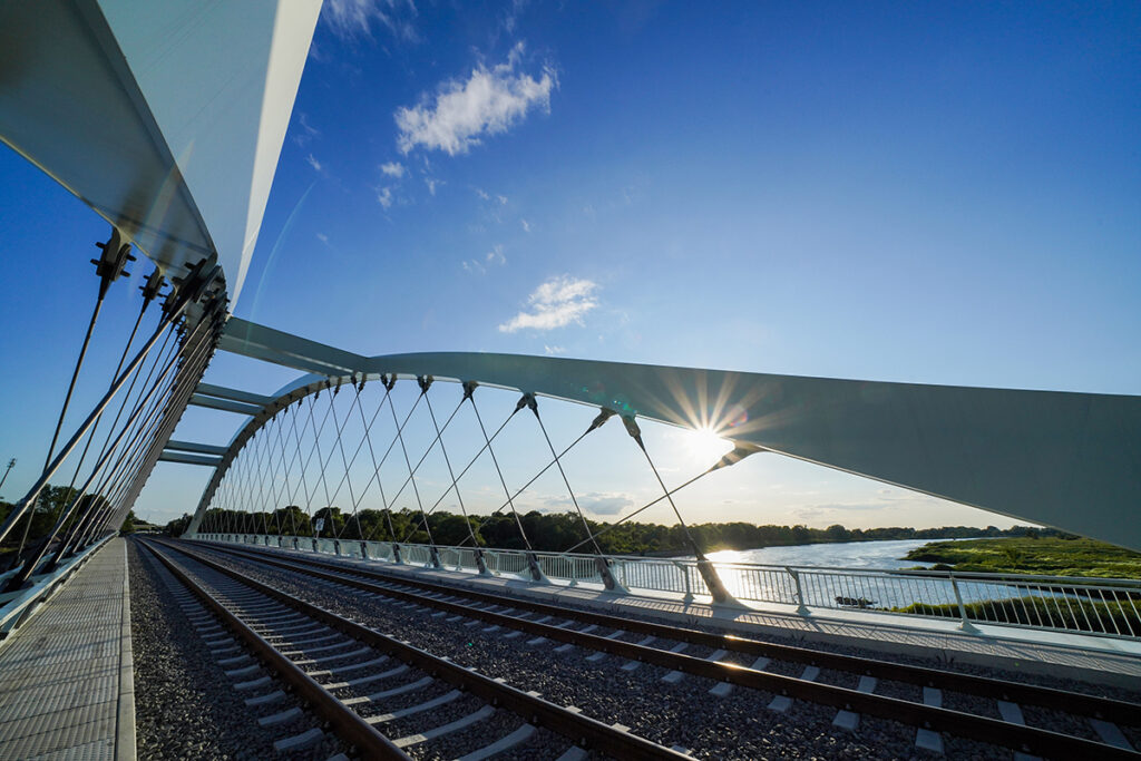 Eine Eisenbahnbrücke führt über einen Fluss.