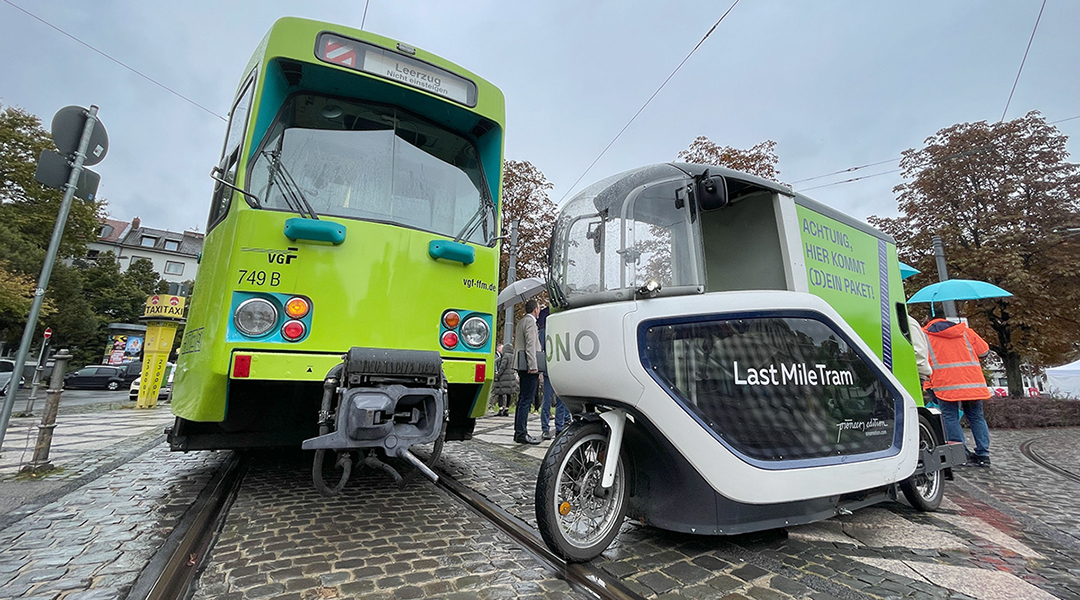 Eine Straßenbahn und ein elektrisches Lastenfahrrad stehen auf der Straße.