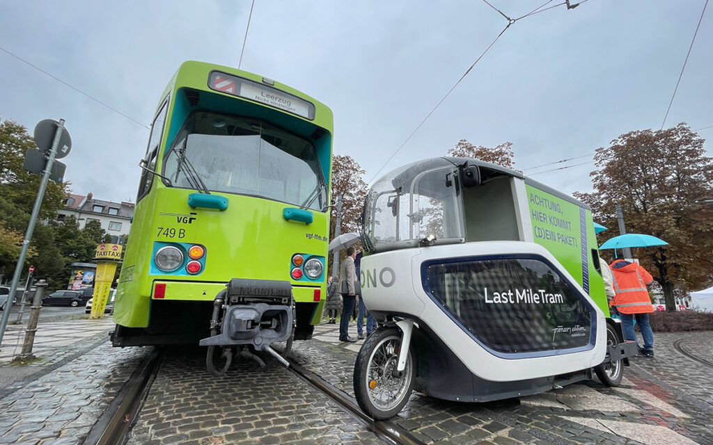 Eine Straßenbahn und ein elektrisches Lastenfahrrad stehen auf der Straße.