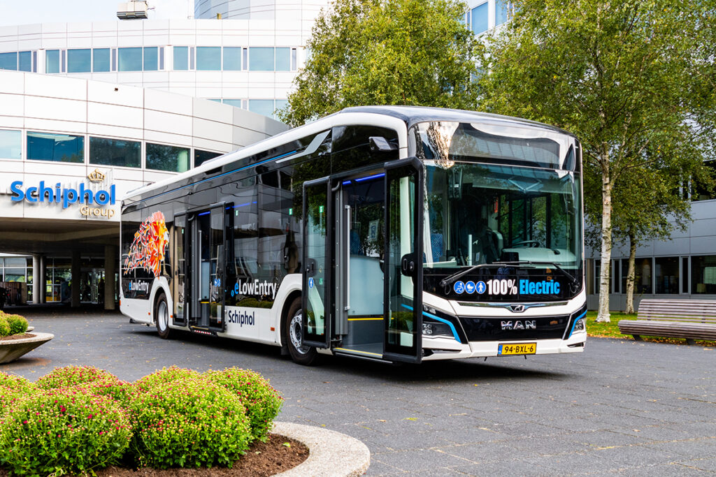 Ein Elektrobus steht vor einem Gebäude.