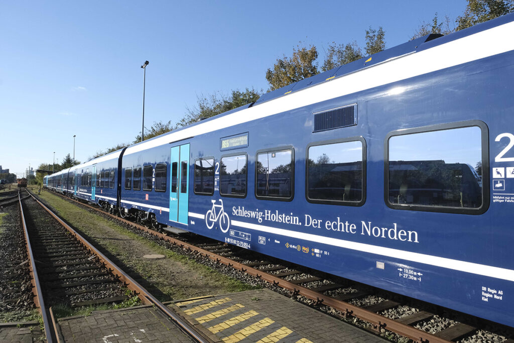 Ein modernisierte Zug steht auf einem Gleis.