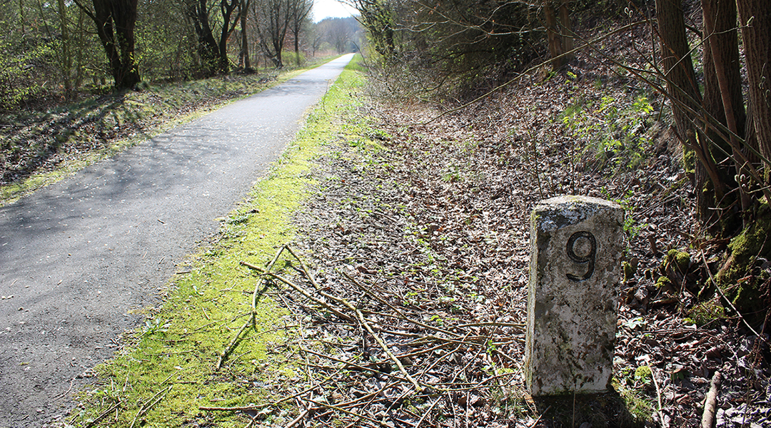 Eine Bahntrasse mit einem Kilometerstein.