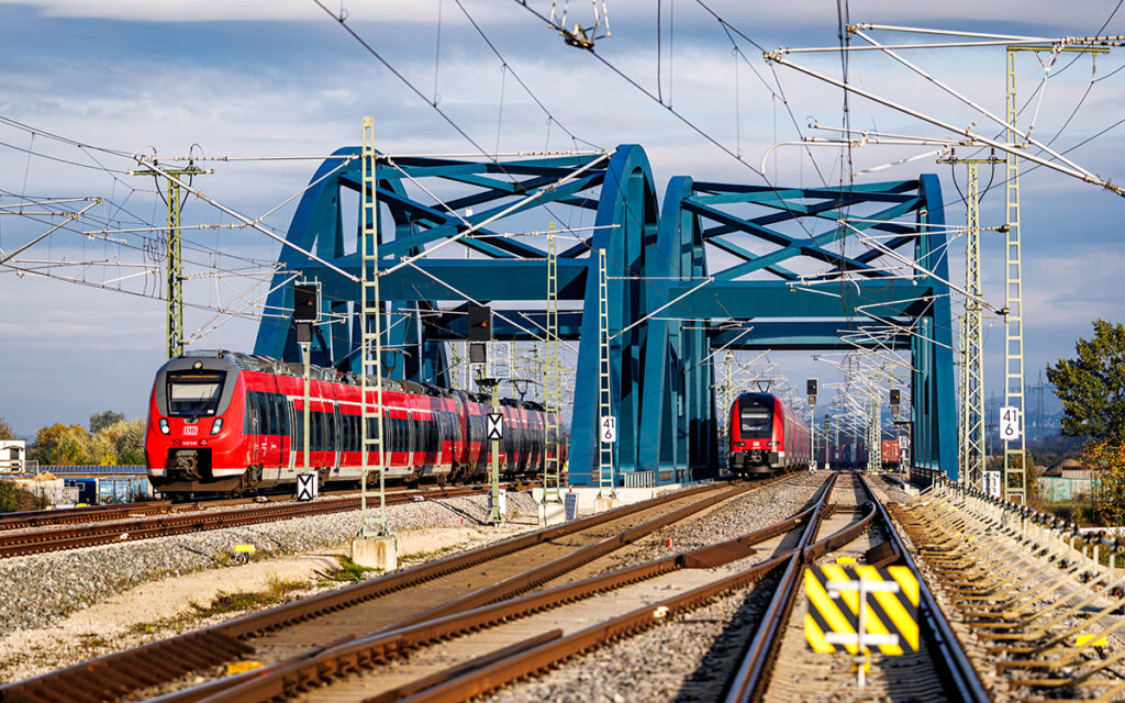 Zwei Züge fahren über zwei Brücken, die nebeneinander gebaut sind.