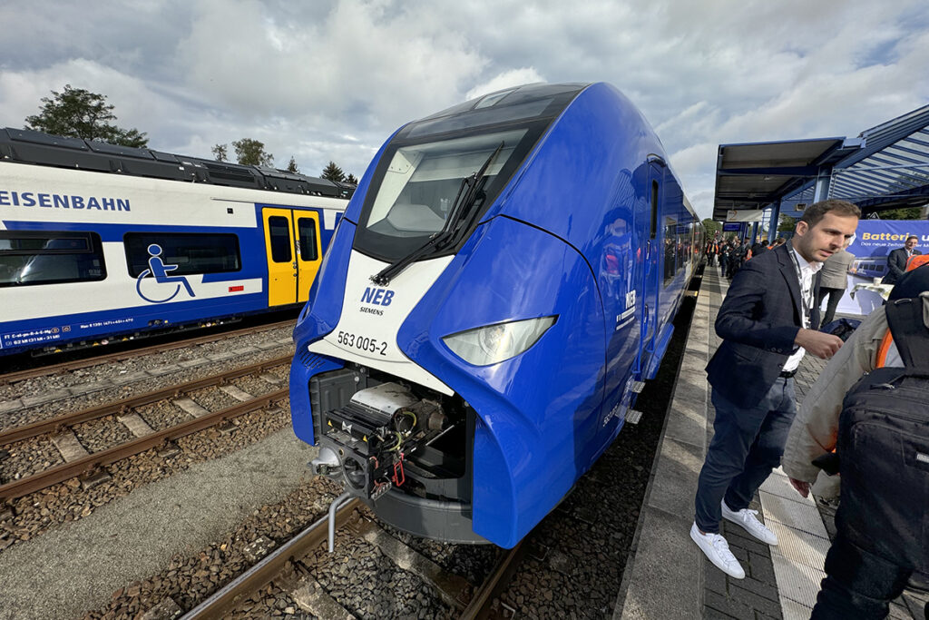 Ein Zug steht an einem Bahnsteig voller Menschen.