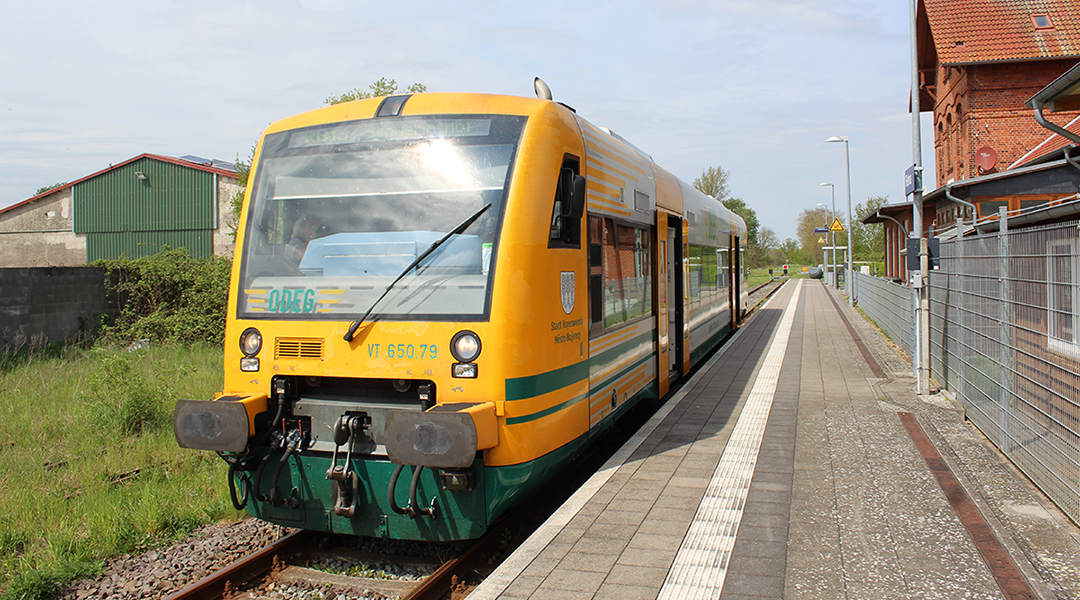 Ein Triebwagen steht an einem Bahnsteig.