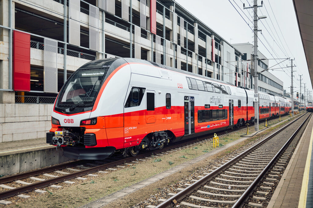 Ein Cityjet-Doppelstockzug steht an einem Bahnsteig.