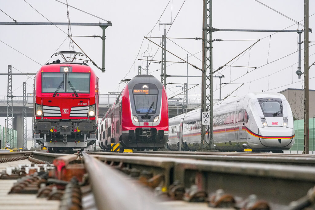 Drei Züge stehen nebeneinander auf Schienen.