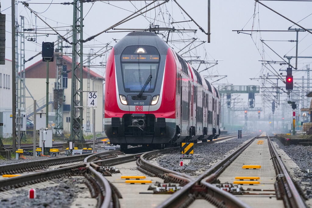 Ein Doppelstockzug fährt auf Schienen.