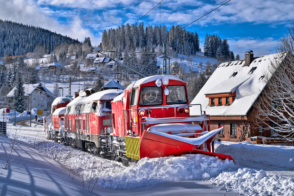 Ein Bahn-Schneepflug schiebt Schnee weg.