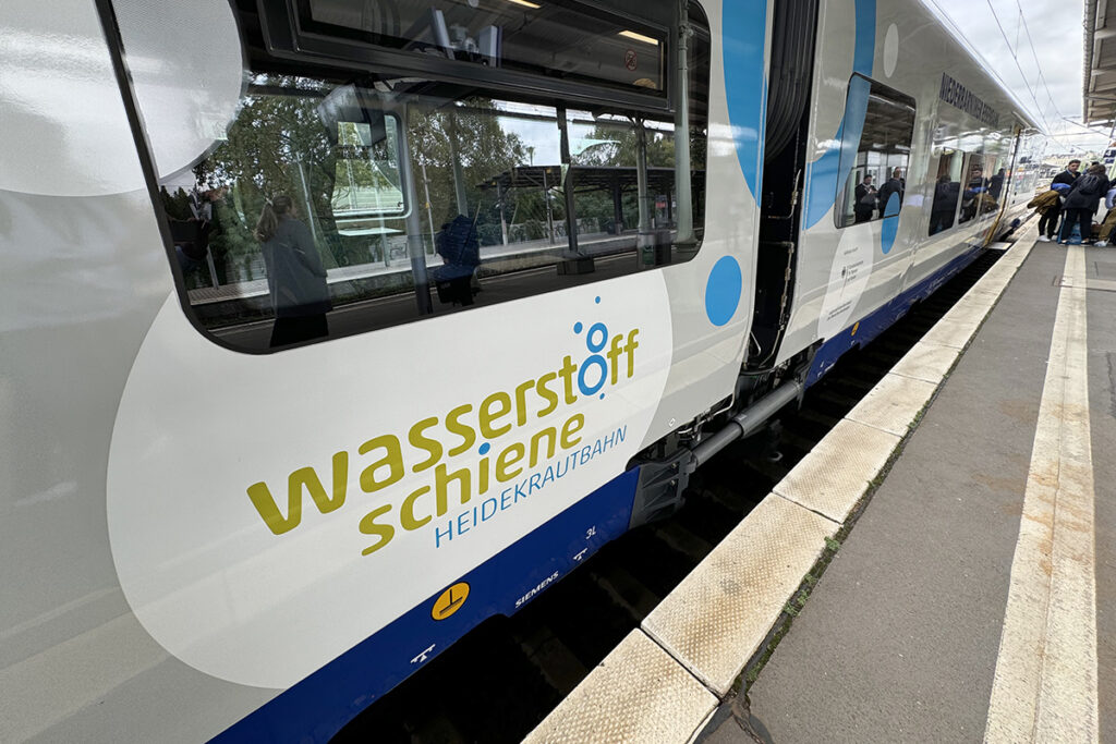 Ein Wasserstoff-Triebzug steht an einem Bahnsteig.