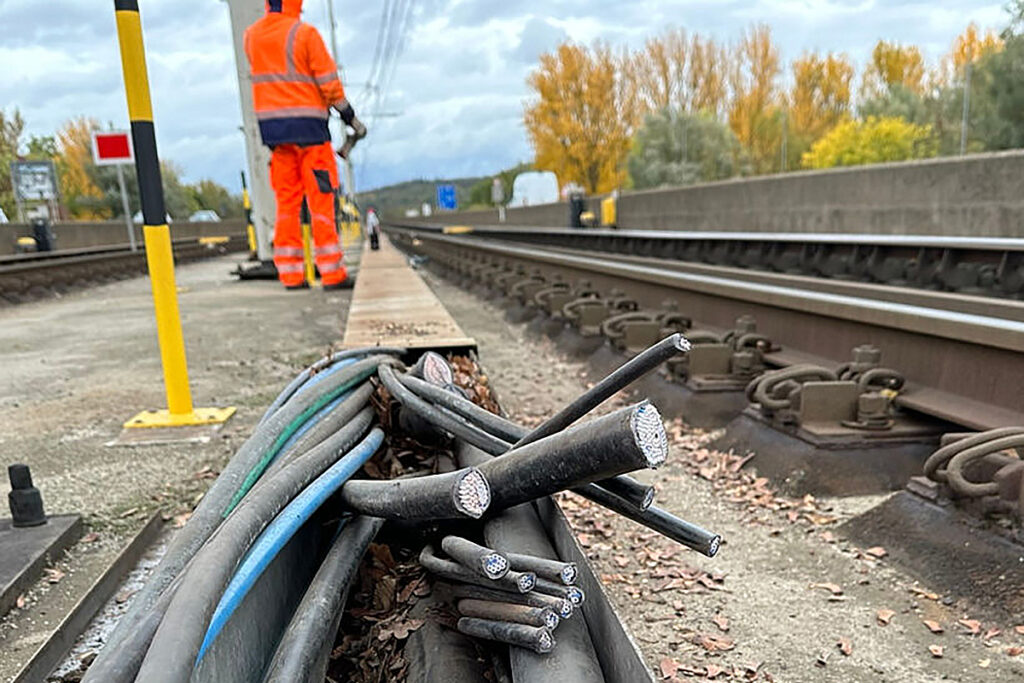 Kabel liegen neben Gleisen.