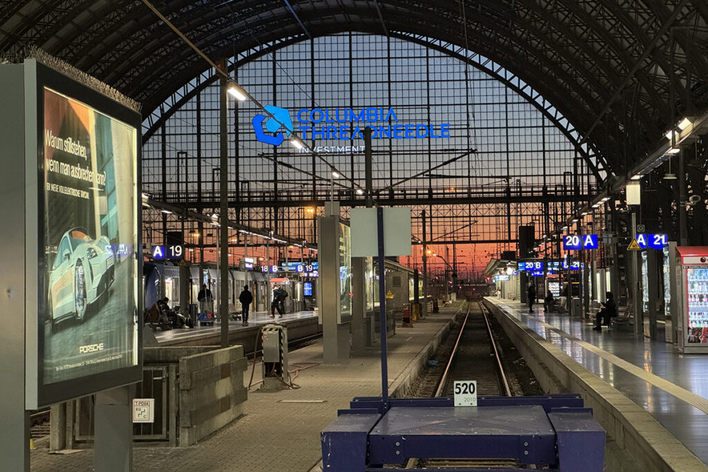 Gleise und Bahnsteige in einer Bahnhofshalle.