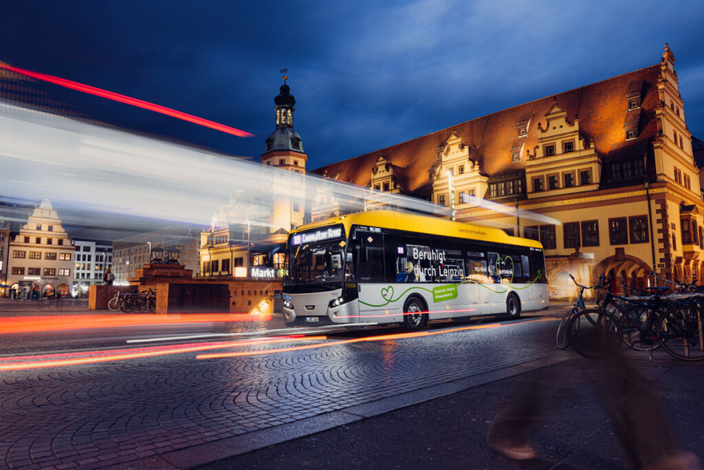 Ein Bus fährt an einem Gebäude vorbei.