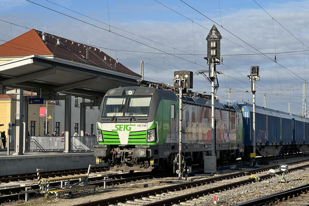 Ein Güterzug steht an einem Bahnsteig.