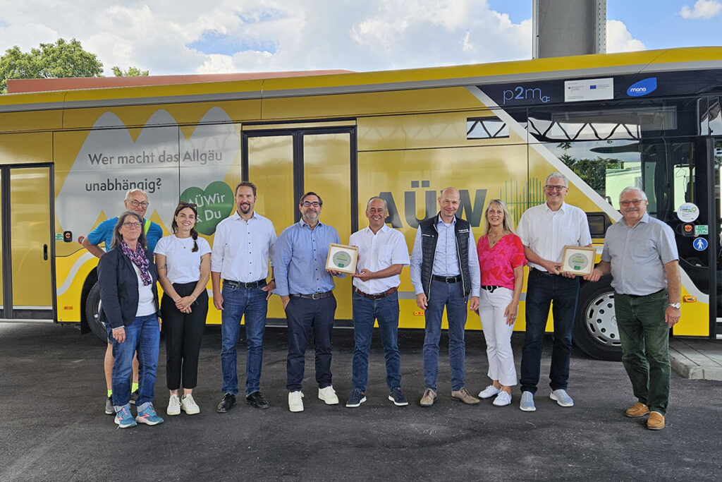 Mehrere Personen stehen vor einem Bus.