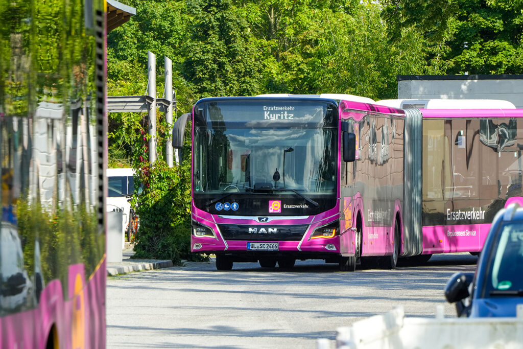 Ein Bus in Schienenersatzverkehr-Lackierung fährt auf einer Straße.