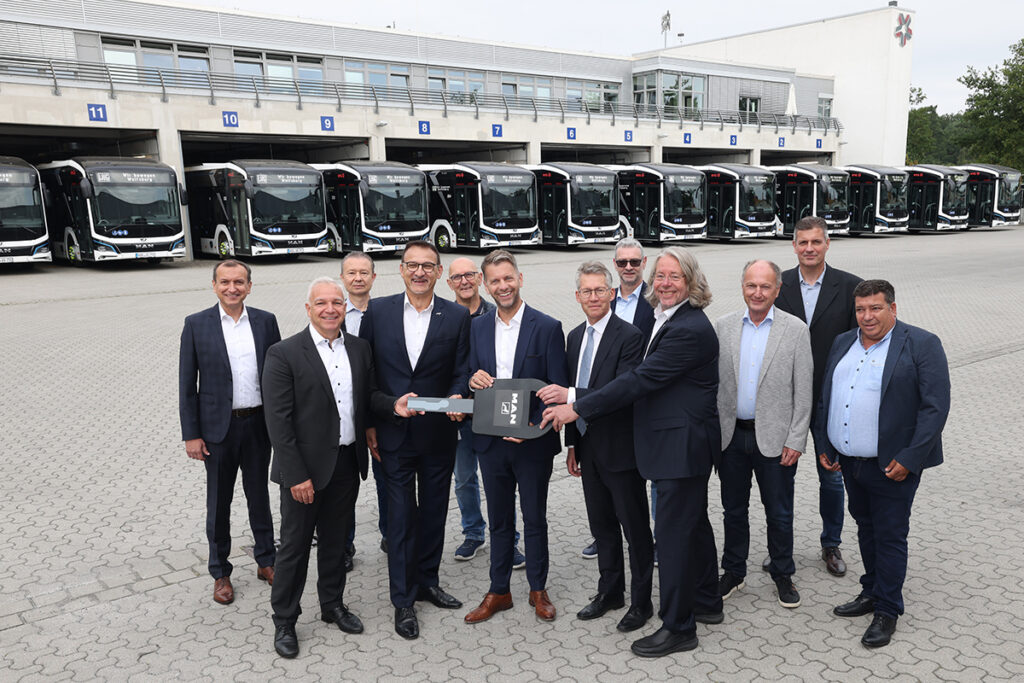 Mehrere Personen stehen vor Bussen.