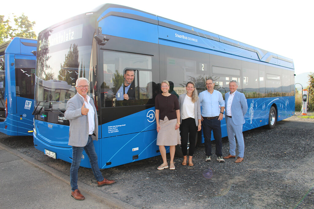 Mehrere Personen stehen vor einem Elektrobus.
