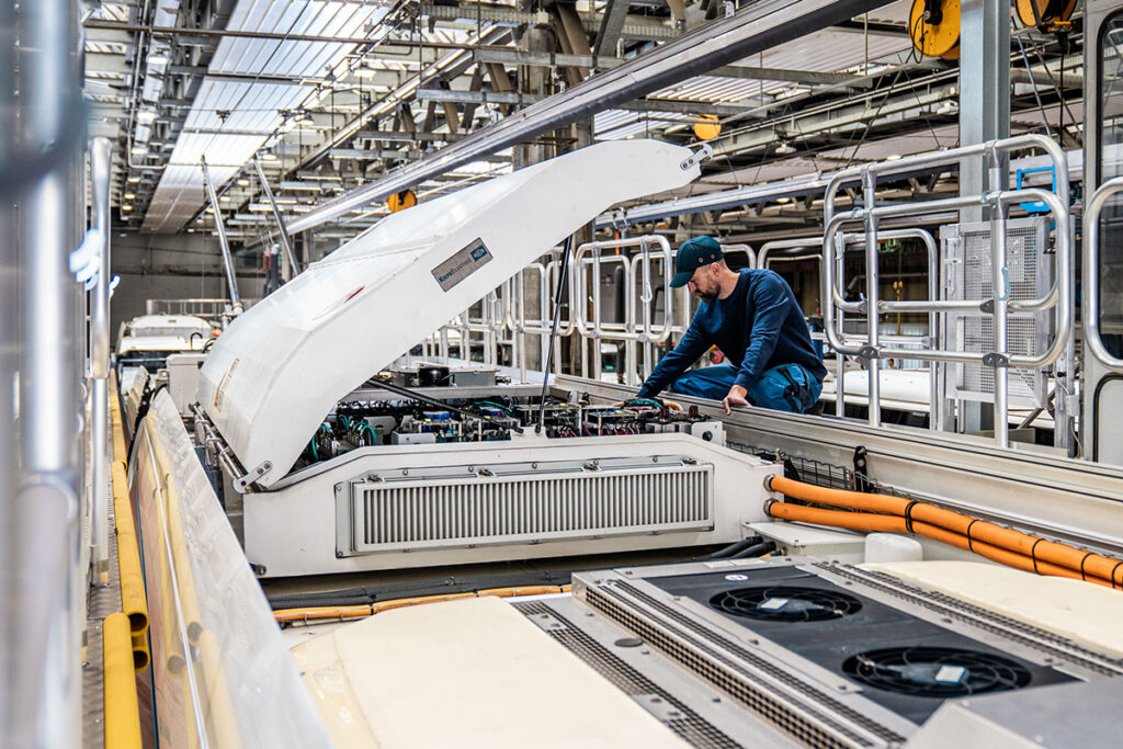 Eine Person arbeitet auf dem Dach eines Elektrobusses.