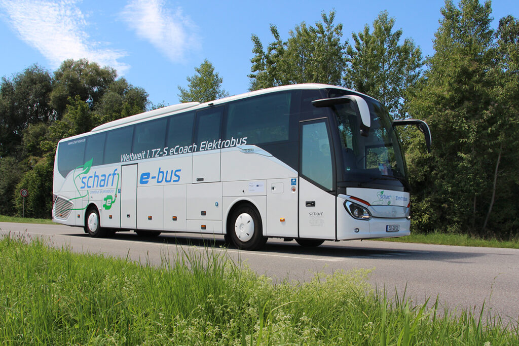 Ein Bus steht auf einer Straße vor Bäumen.