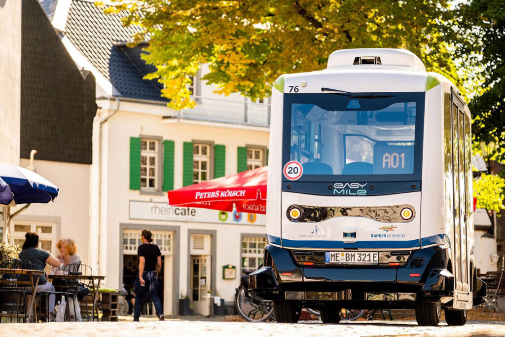 Ein Kleinbus fährt vor Altstadthäusern.