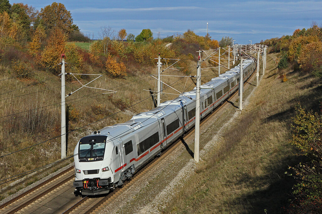 Ein ICE L fährt auf einer zweigleisigen Strecke durch einen Einschnitt.