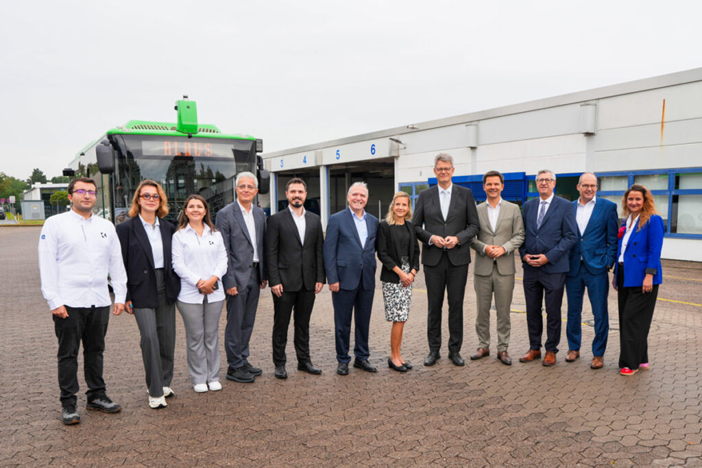 Mehrere Personen stehen vor einem autonomen Elektrobus.