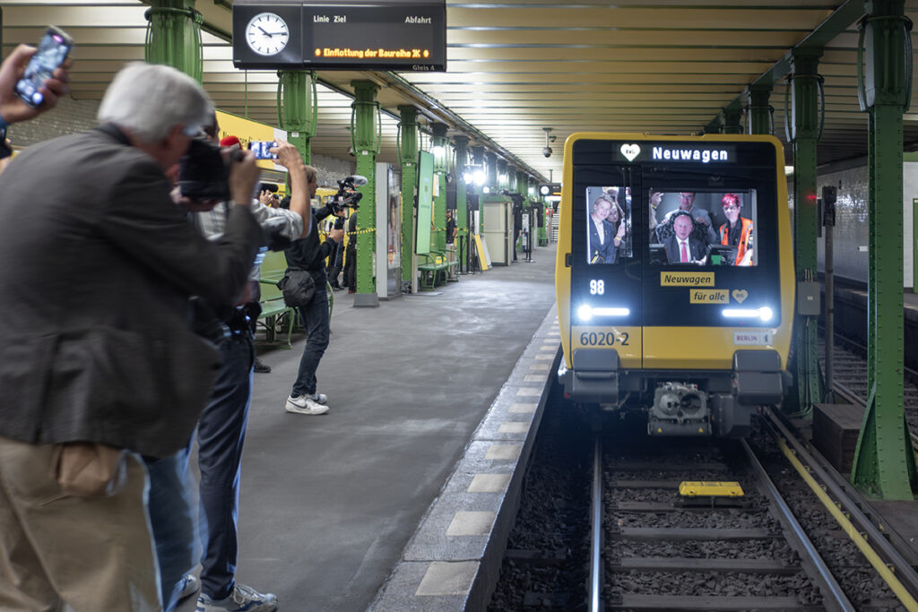 Eine U-Bahn fährt in eine unterirdische Haltestelle ein.