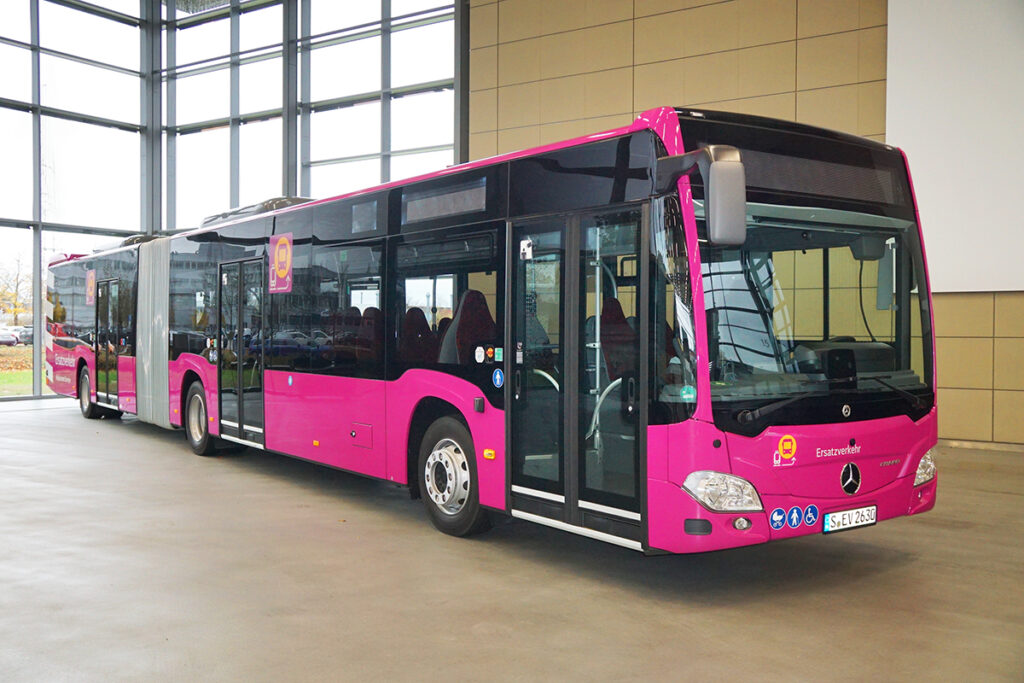 Ein Gelenkbus steht in einer Halle.