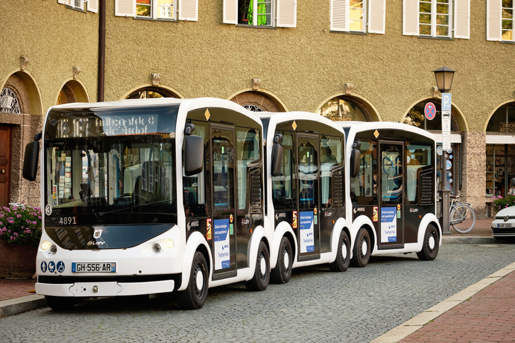 Drei Kleinbusse stehen in einer Straße.