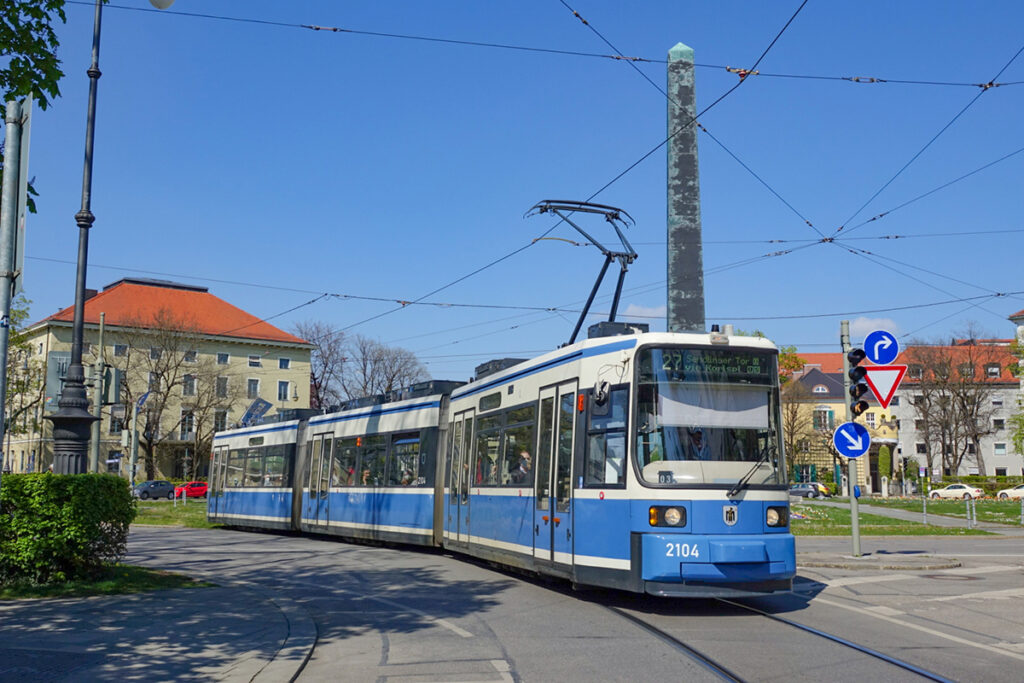 Eine Straßenbahn fährt über einen begrünten Platz.
