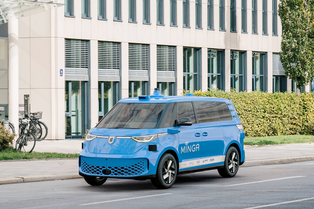 Ein Kleinbus steht vor einem mehrstöckigen Gebäude.
