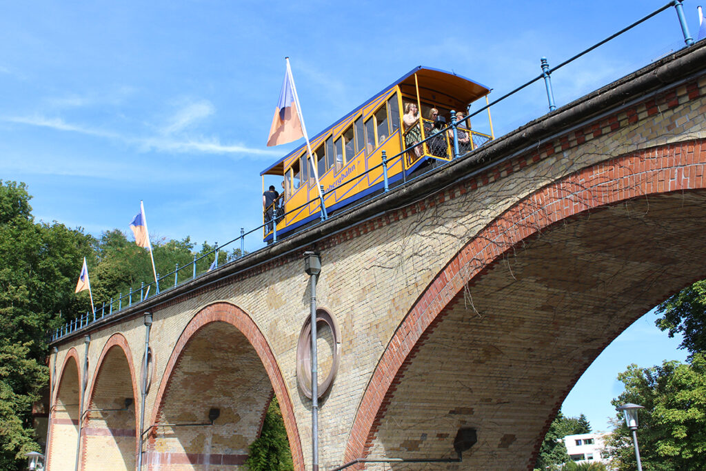 Der Wagen einer Standseilbahn fährt über ein Viadukt.