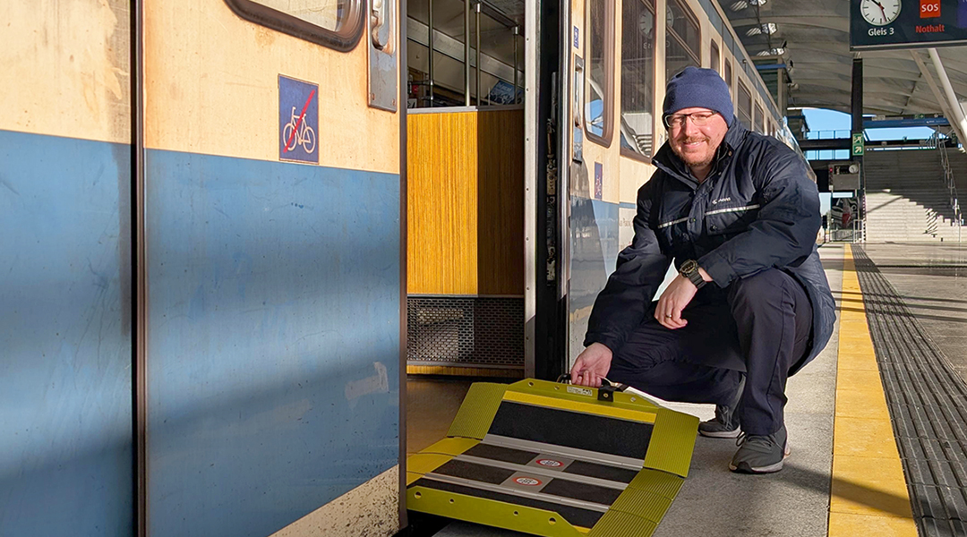 Eine Person mit Faltrampe vor einer U-Bahn.