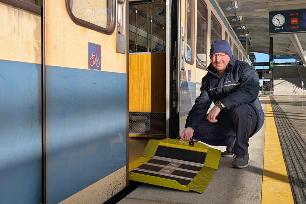 Eine Person mit Faltrampe vor einer U-Bahn.