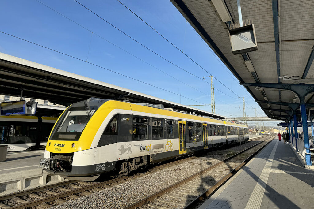 Ein Triebzug steht an einem Bahnsteig.