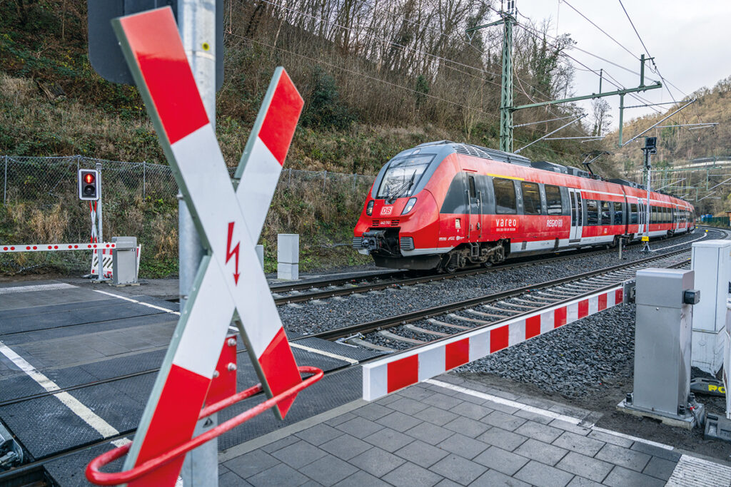 Ein Zug fährt über einen Bahnübergang.