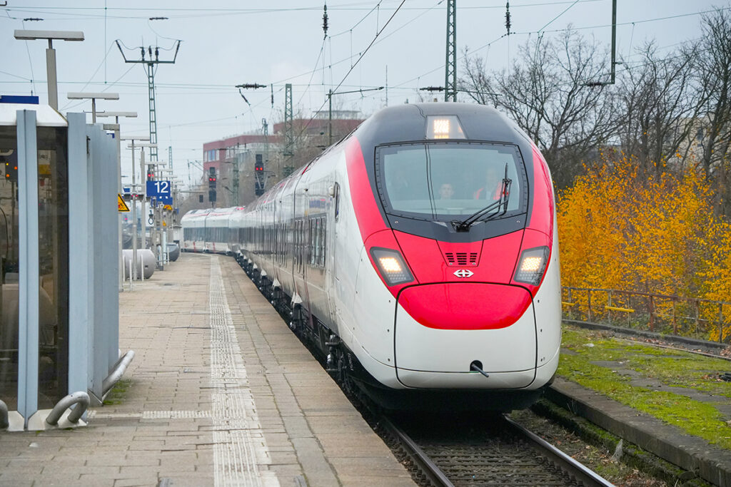 Ein Giruno-Triebzug fährt an einem Bahnsteig ein.
