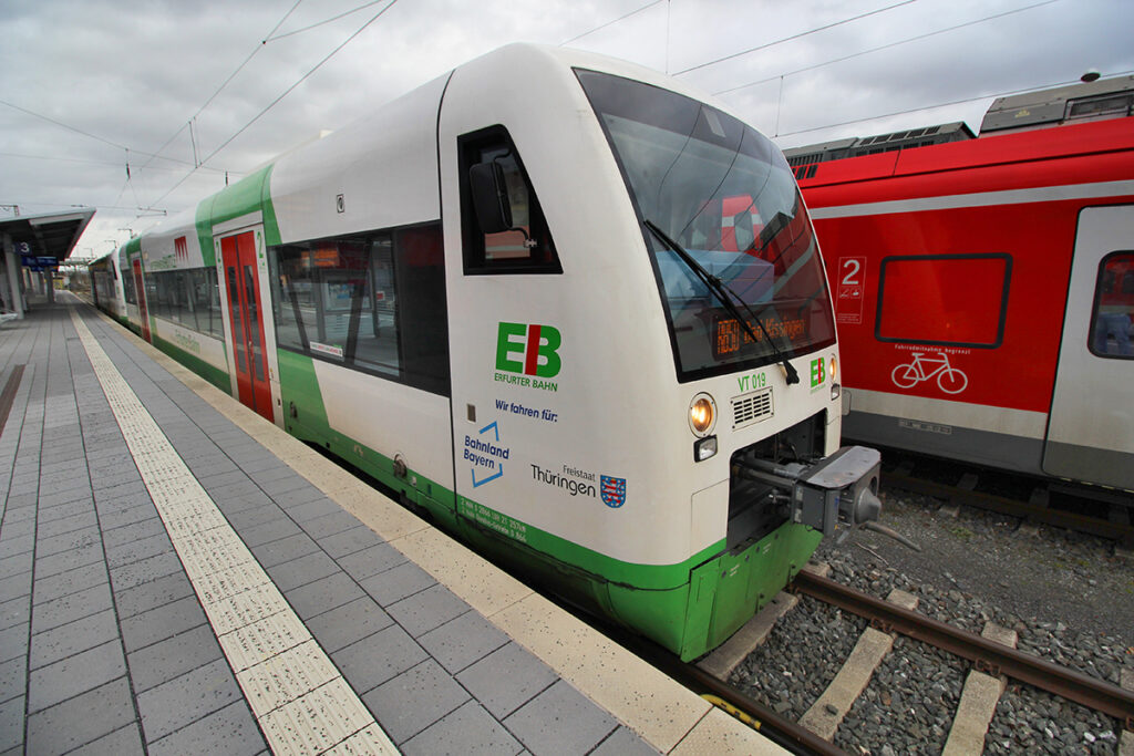 Ein Triebzug steht an einem Bahnsteig.
